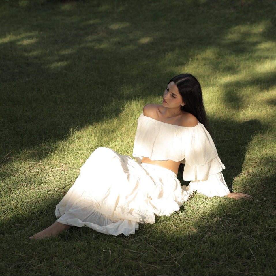 Woman in a white set sitting on grass